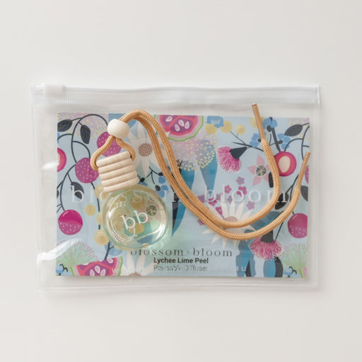 Small bottle with a beige cap and strap on a colorful floral background